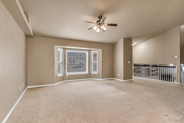 carpeted empty room featuring baseboards and ceiling fan