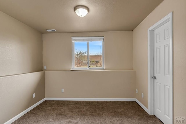 spare room with visible vents, baseboards, and carpet