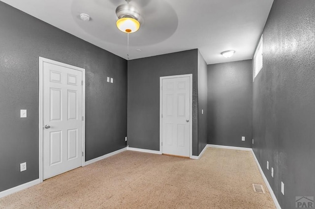 unfurnished bedroom with carpet, baseboards, a ceiling fan, and visible vents