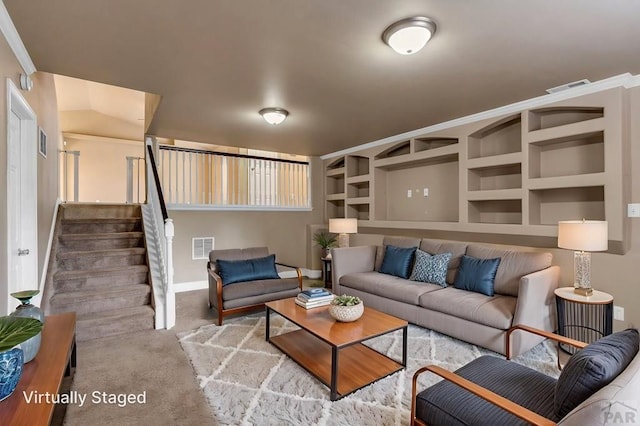living area featuring visible vents, built in shelves, stairway, and carpet