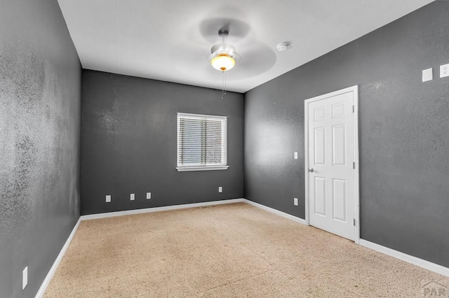empty room with a textured wall, baseboards, and ceiling fan