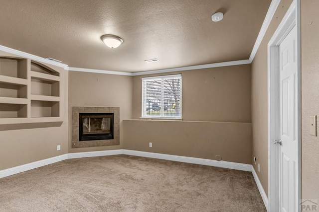 unfurnished living room featuring a tile fireplace, visible vents, a textured ceiling, and carpet floors