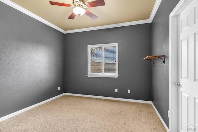 spare room with visible vents, baseboards, a ceiling fan, crown molding, and carpet flooring