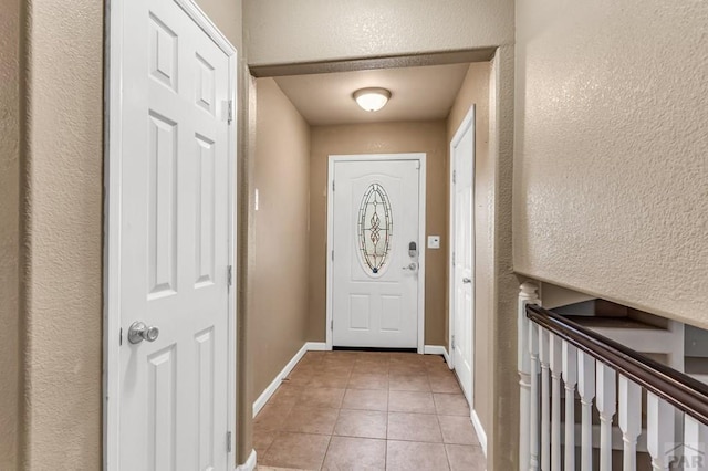 entryway featuring light tile patterned floors and baseboards