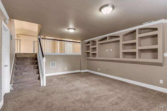 below grade area featuring visible vents, baseboards, carpet flooring, and stairs