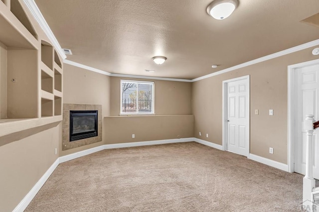 unfurnished living room featuring crown molding, a tile fireplace, baseboards, and carpet