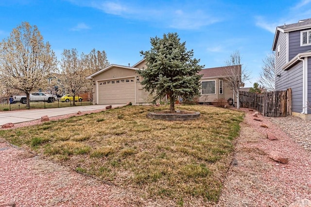 view of front of home with concrete driveway, stucco siding, a front lawn, a garage, and fence