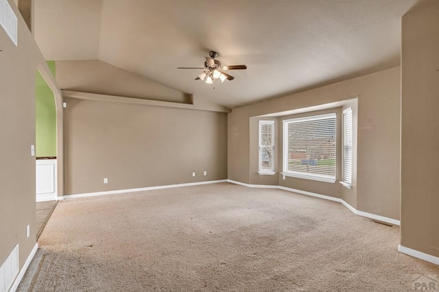 spare room with ceiling fan, baseboards, lofted ceiling, and carpet