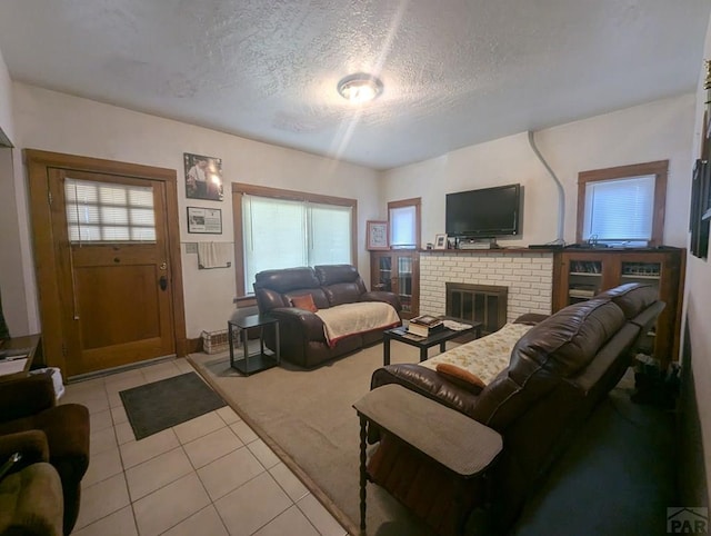 living room featuring light tile patterned flooring, a textured ceiling, and a fireplace