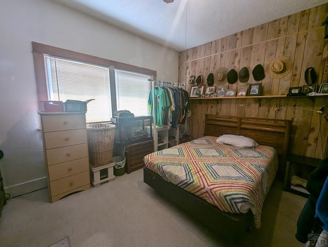 carpeted bedroom featuring wooden walls
