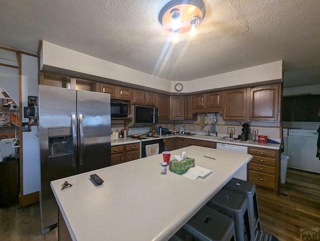 kitchen featuring stainless steel refrigerator with ice dispenser, electric stove, light countertops, and a textured ceiling