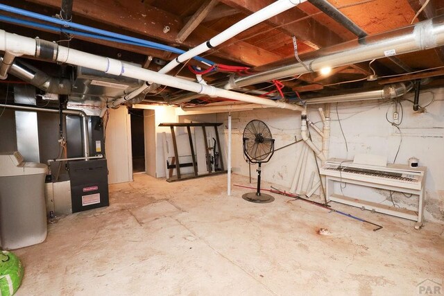 unfinished basement featuring heating unit