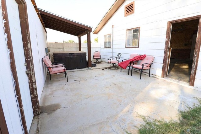 view of patio / terrace with a fenced backyard and a hot tub