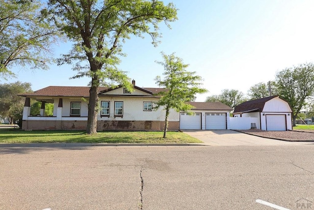 ranch-style home with a detached garage and a front yard