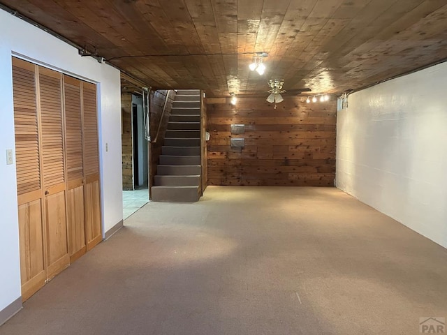 interior space with carpet floors, wood ceiling, wooden walls, and stairway