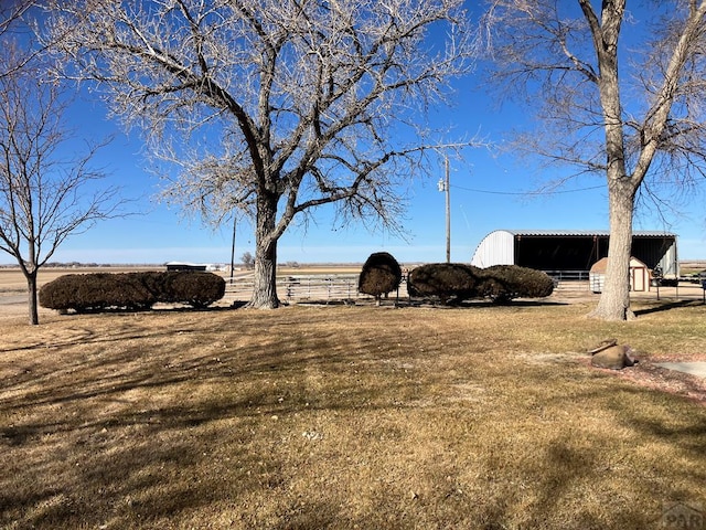 view of yard featuring a rural view and an outdoor structure