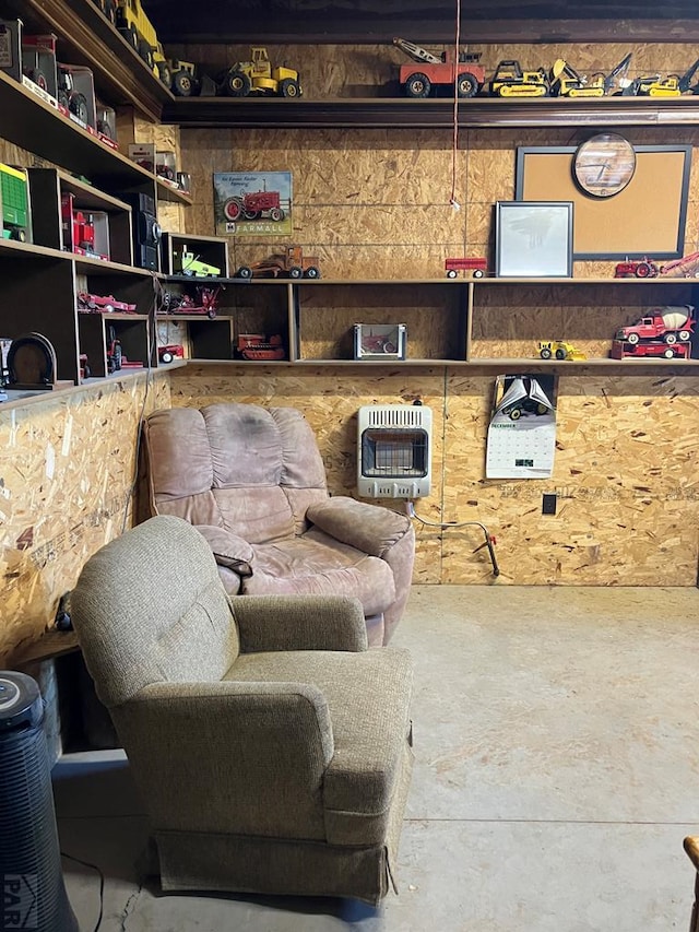 living area with unfinished concrete floors and heating unit