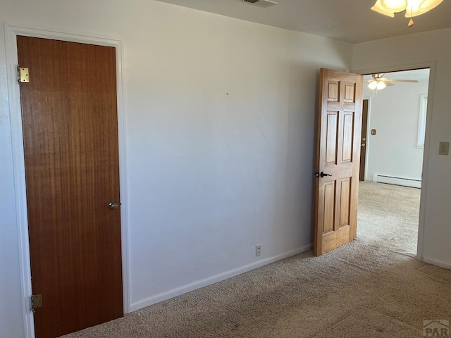 spare room featuring baseboards, visible vents, baseboard heating, and light colored carpet