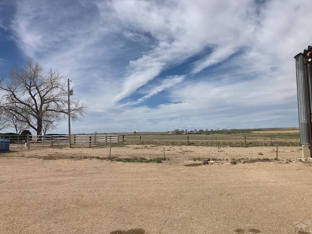 view of yard featuring fence and a rural view