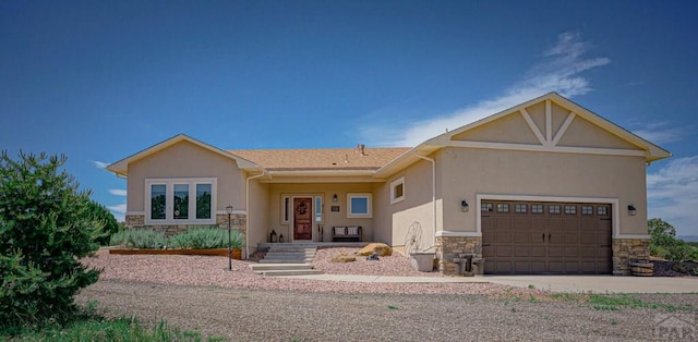 view of front facade featuring a garage, stone siding, and stucco siding