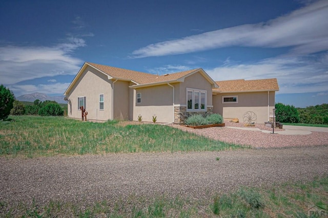 view of front of property featuring stone siding and stucco siding