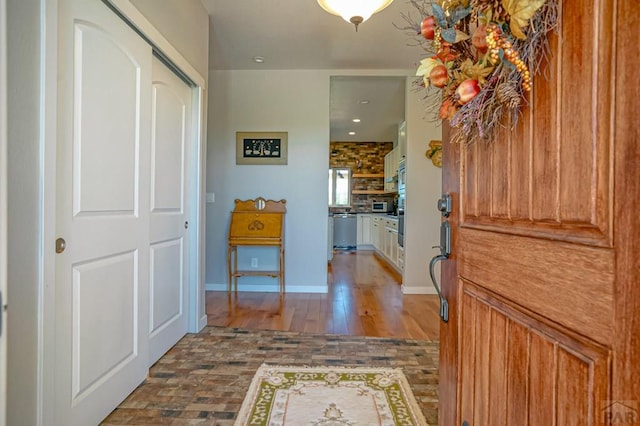 hall featuring baseboards and wood finished floors
