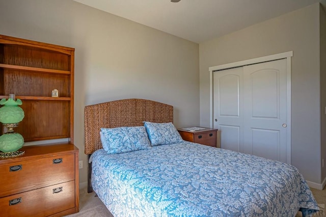 bedroom featuring light carpet, baseboards, and a closet