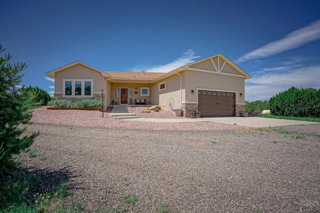 view of front of property with a garage, stone siding, driveway, and stucco siding