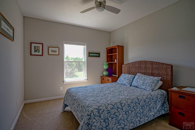 carpeted bedroom with ceiling fan and baseboards