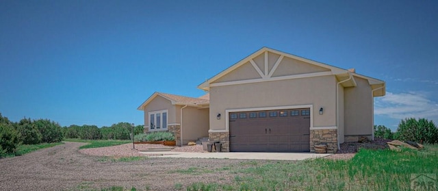 view of front facade with stone siding, an attached garage, and stucco siding