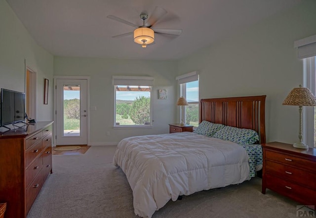 bedroom featuring light carpet, access to outside, baseboards, and ceiling fan
