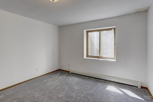 carpeted empty room with baseboard heating and baseboards