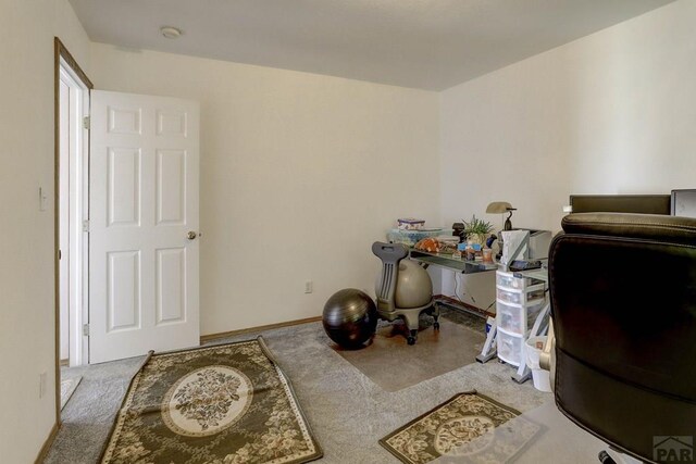 carpeted home office featuring baseboards