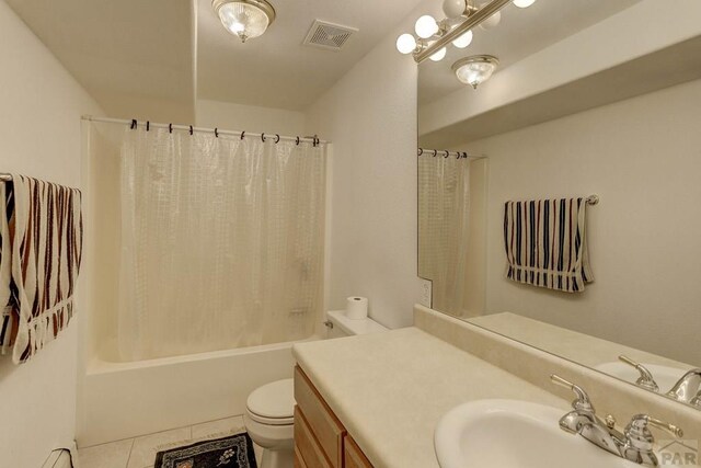 bathroom featuring toilet, vanity, visible vents, tile patterned floors, and shower / tub combo with curtain