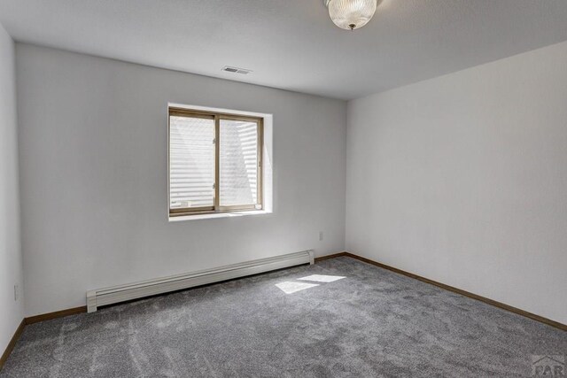 carpeted spare room with baseboards, visible vents, and baseboard heating