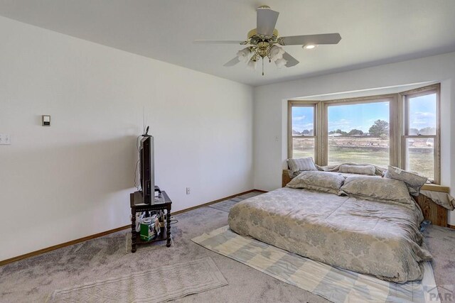 bedroom with light carpet, a ceiling fan, and baseboards