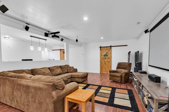 living area with recessed lighting, light wood finished floors, and a barn door