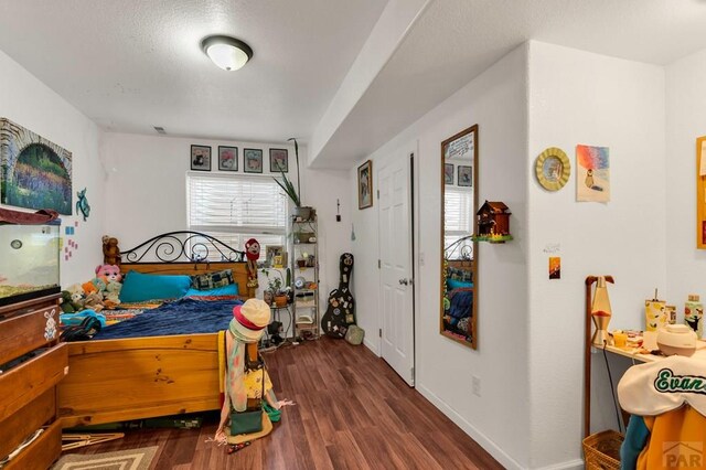 bedroom featuring dark wood finished floors and baseboards