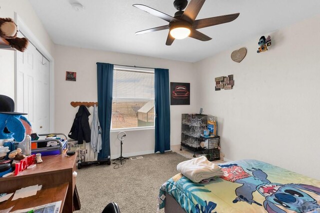 carpeted bedroom featuring a closet, a ceiling fan, and baseboards