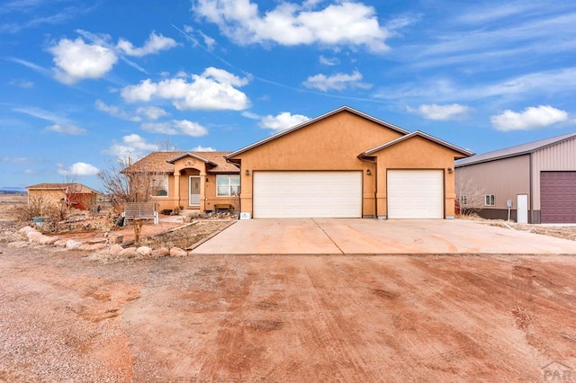 ranch-style home featuring concrete driveway and stucco siding