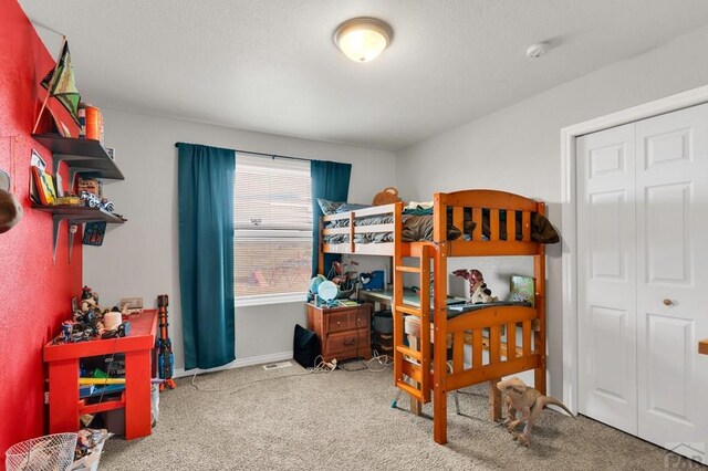 bedroom featuring carpet, baseboards, and a closet