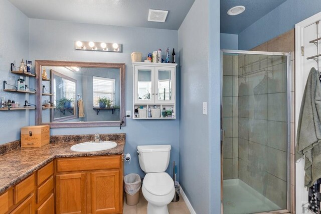 bathroom with visible vents, toilet, a stall shower, vanity, and baseboards