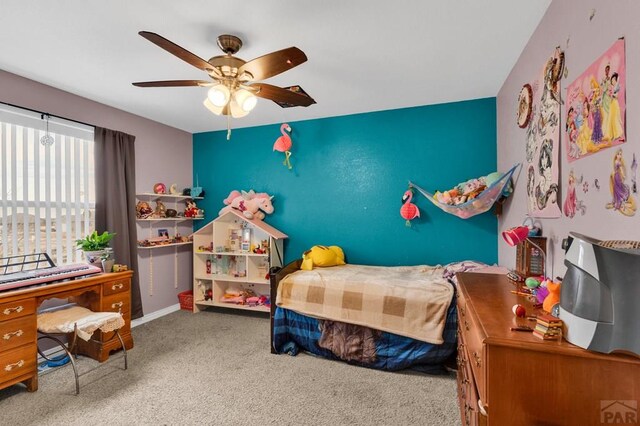 carpeted bedroom with a ceiling fan and baseboards