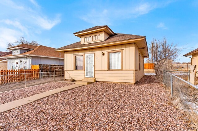 bungalow-style house featuring board and batten siding and fence