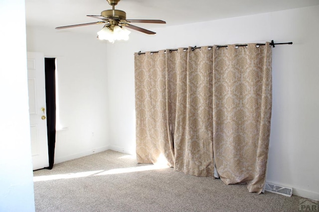 unfurnished room featuring visible vents, baseboards, ceiling fan, and carpet flooring