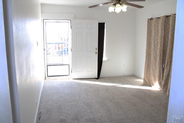 spare room featuring a ceiling fan, carpet, and baseboards