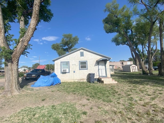 rear view of property with a shed, a lawn, and an outdoor structure