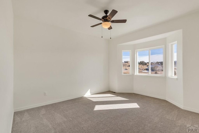 unfurnished room with light carpet, ceiling fan, and baseboards