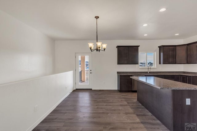 kitchen with dark wood-style floors, hanging light fixtures, dark brown cabinets, a notable chandelier, and recessed lighting