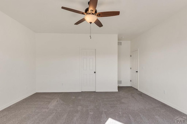 carpeted empty room with ceiling fan, visible vents, and baseboards